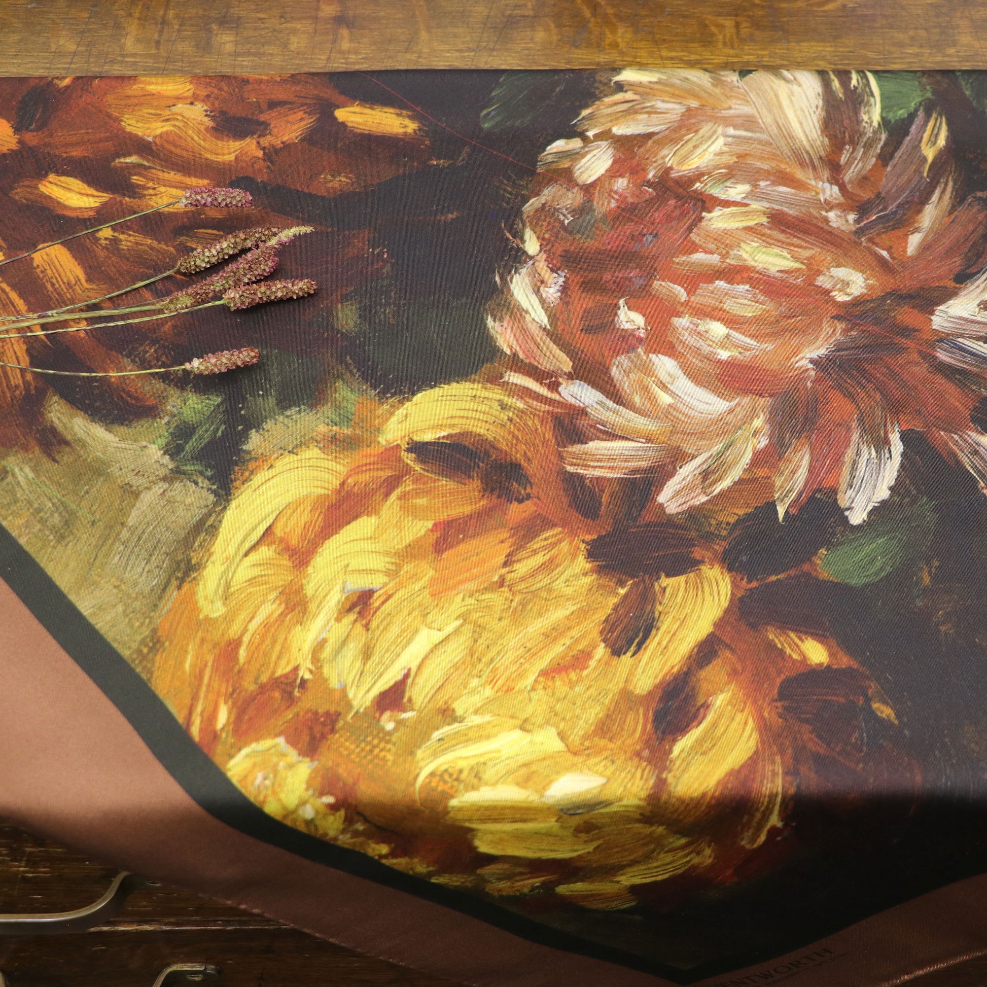 Blooms of Autumn silk scarf shown laid on table.
