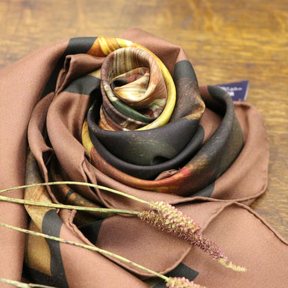 Blooms of Autumn silk scarf wrapped as a rose, shown on wooden table with foliage
