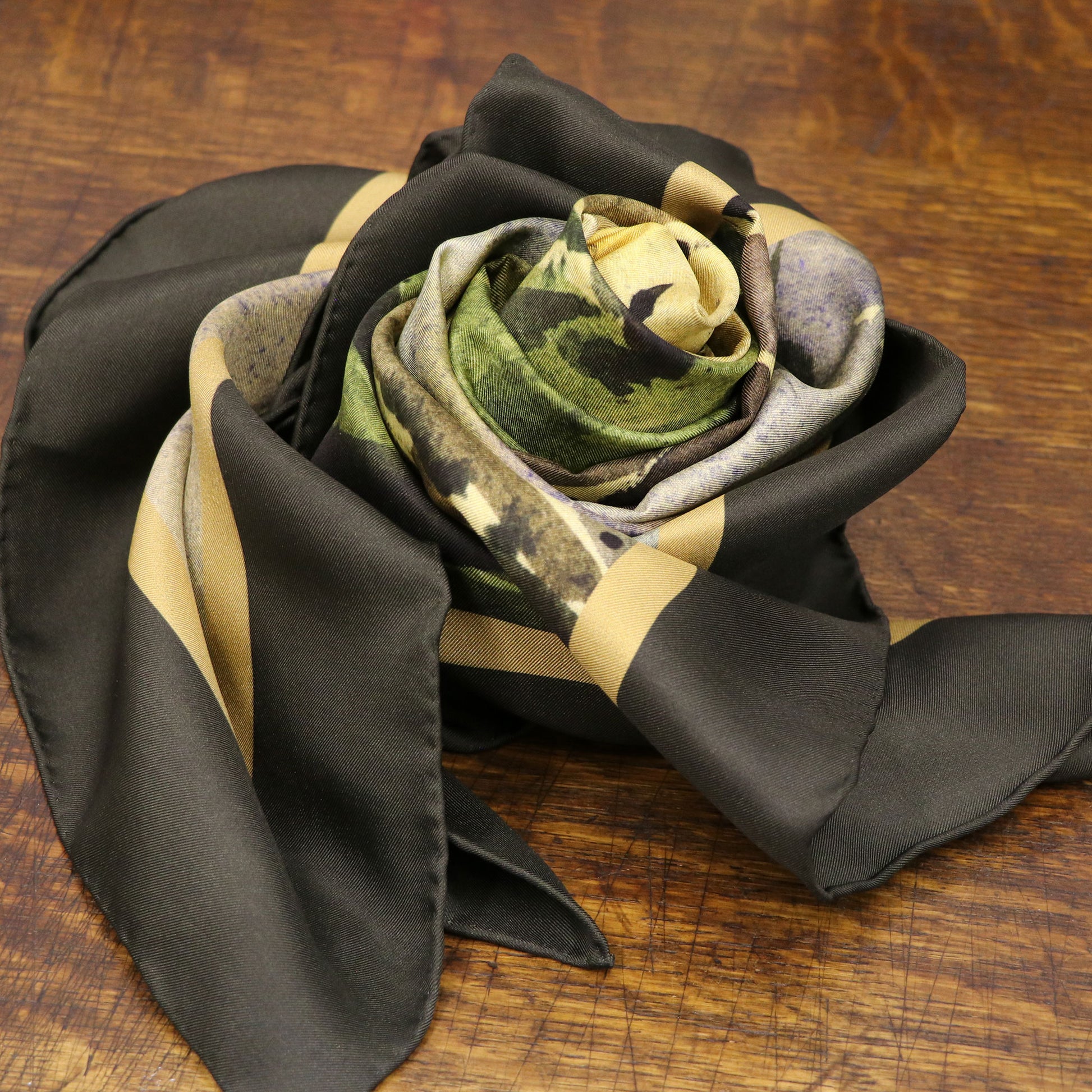 By the Castle Gate silk scarf folded as a rose on wooden table | Silk Scarf | Wentworth of Yorkshire.