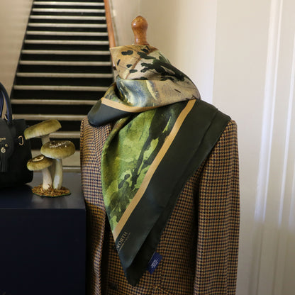 Mannequin wearing tweed jacket with By the Castle Gate silk scarf draped around neck.